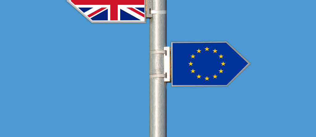 Es ist ein Pfosten zu sehen an dem 2 Schilder in jeweils eine Richtung zeigen. Auf dem einem Schild ist die Fallge von GB auf der anderen die der EU.