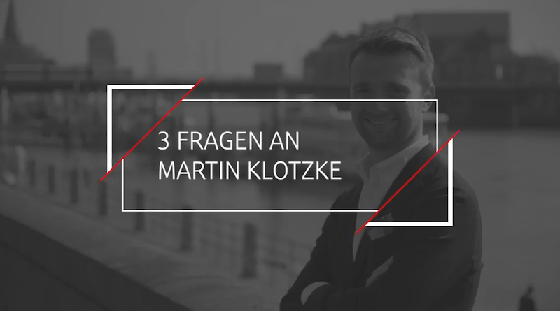 Ein Kasten in der Mitte "3 Fragen an Martin Klotzke" Der Hintergrund ist grau und man sieht einen Mann am Geländer lehnen